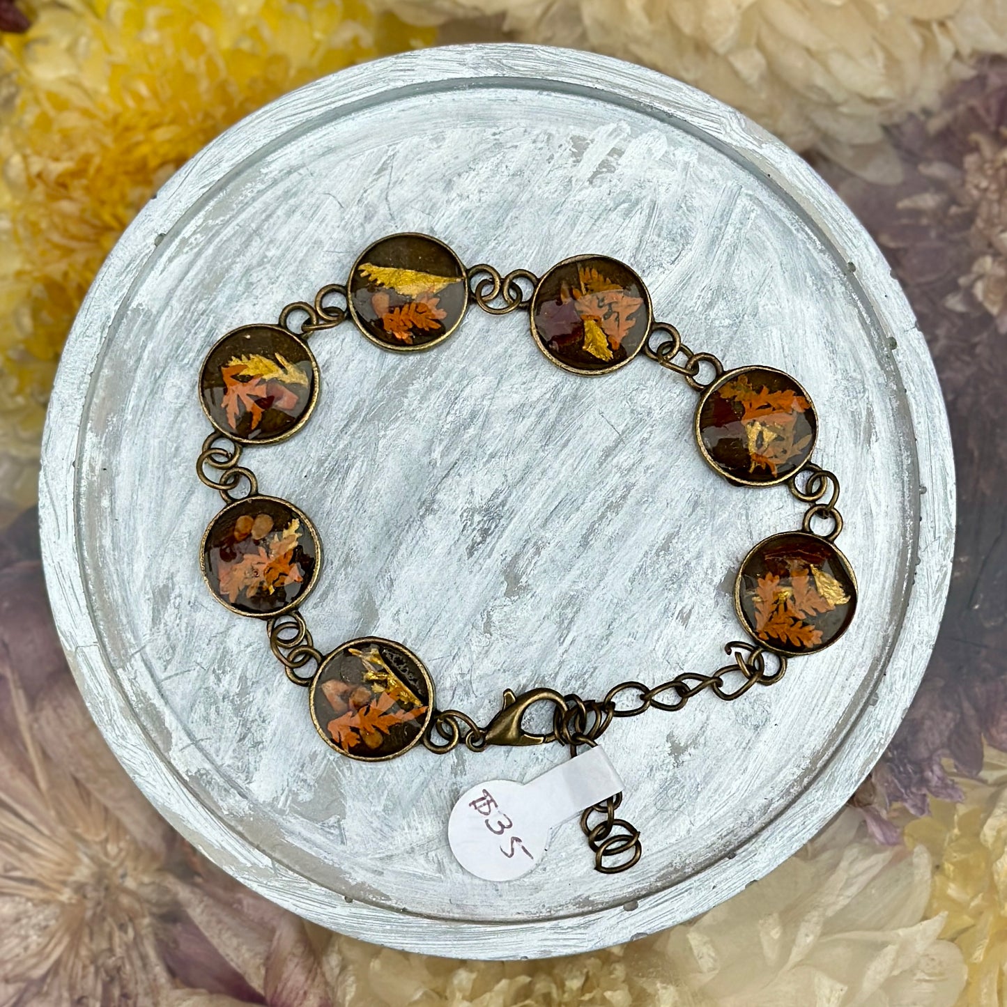 Autumn botanical bracelet with 7 baubles in bronze setting (orange, red, and yellow)