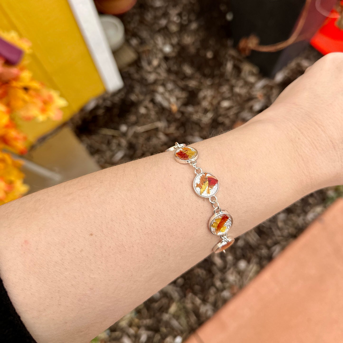 Autumn botanical bracelet with 7 baubles in silver setting (orange, red, and yellow)