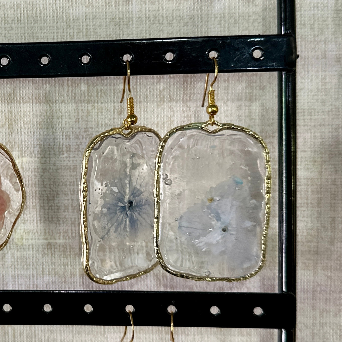Gold-framed botanical earrings in pale indigo