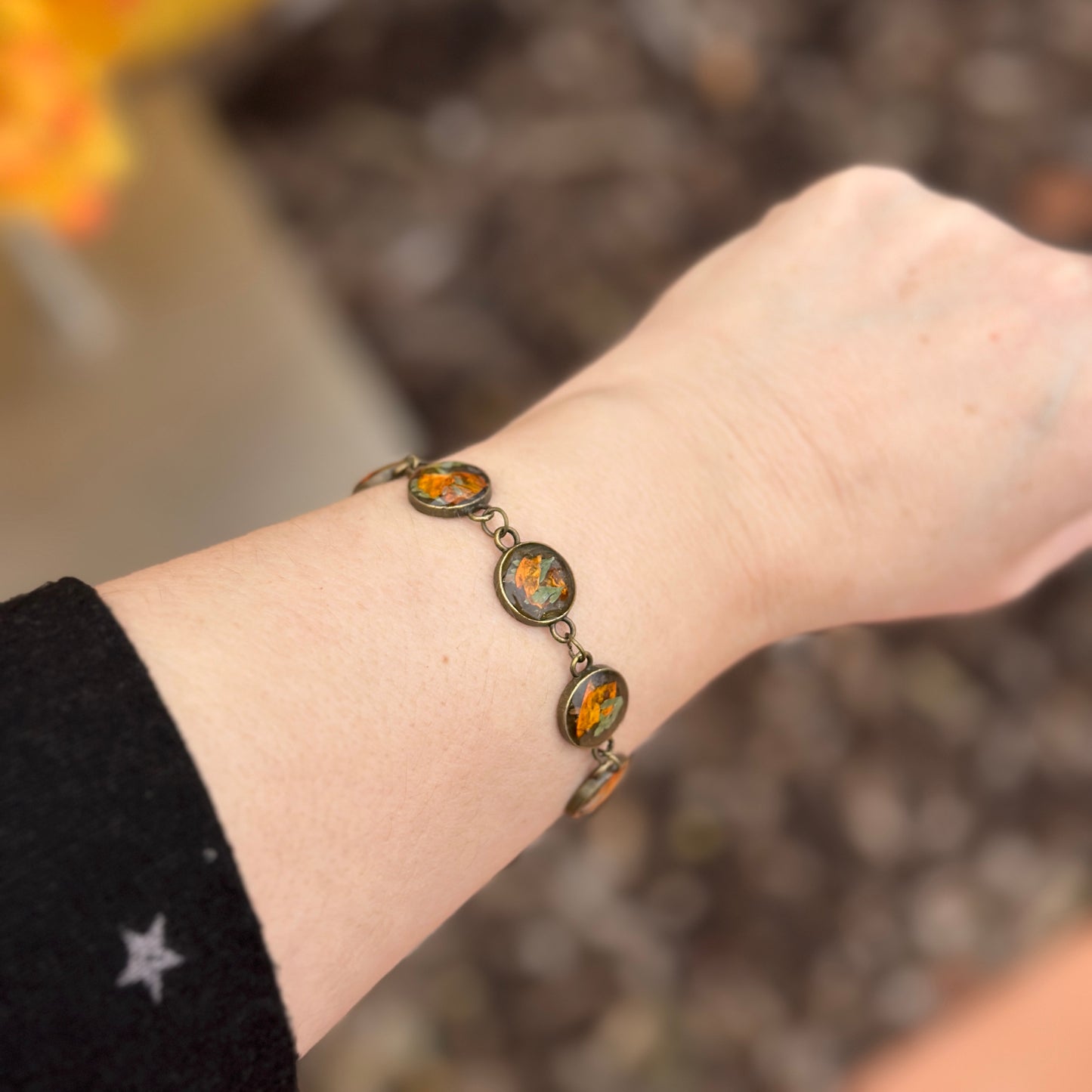 Autumn botanical bracelet with 7 baubles in bronze setting (orange and green)