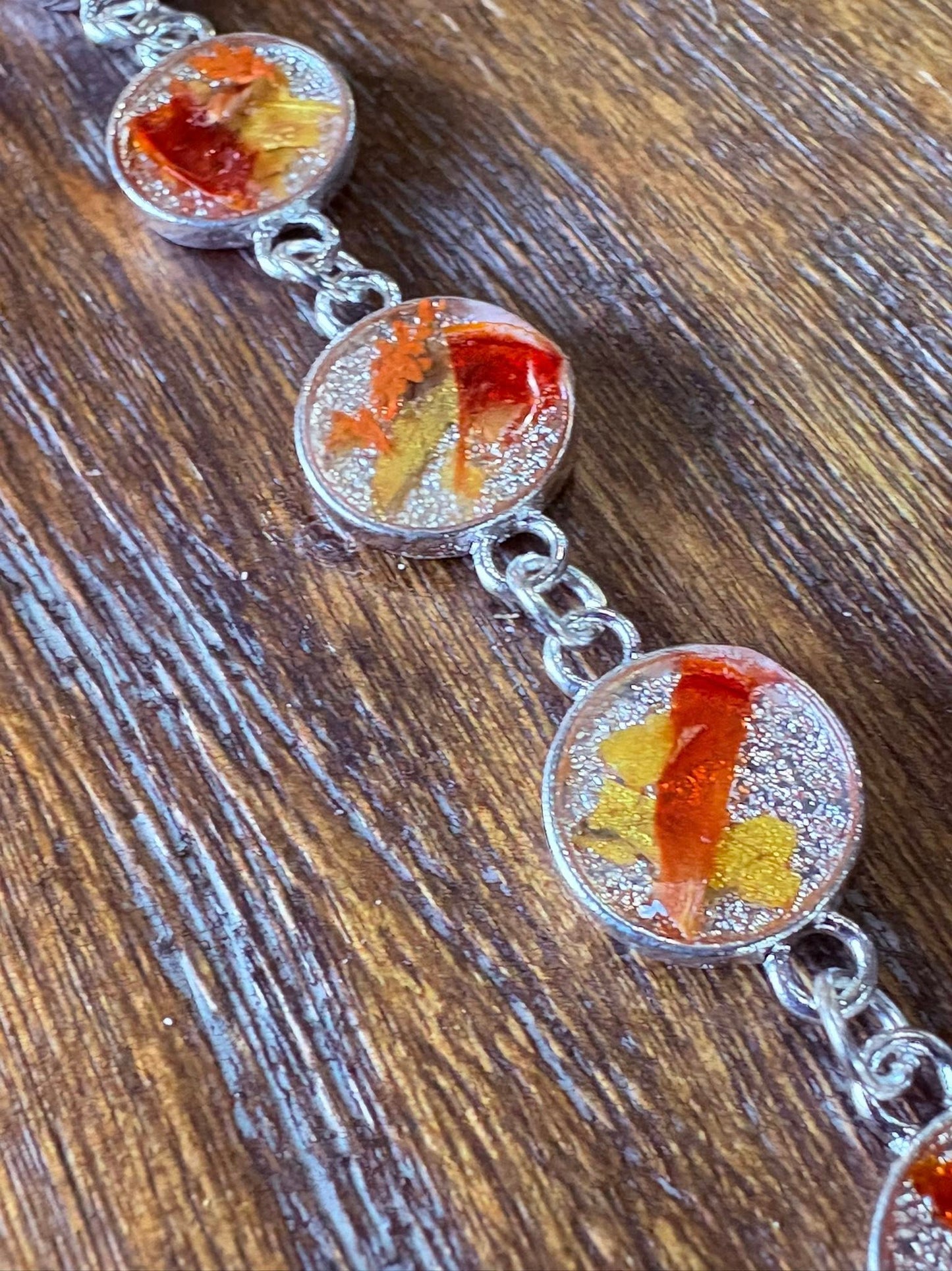 Autumn botanical bracelet with 7 baubles in silver setting (orange, red, and yellow)