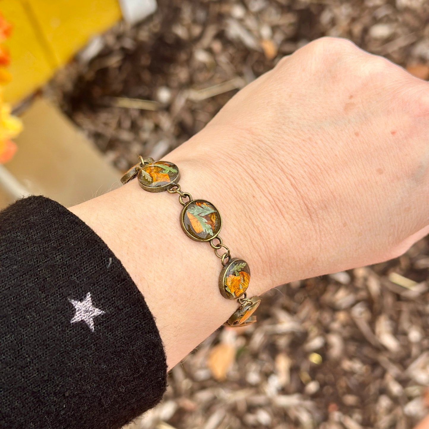 Autumn botanical bracelet with 7 baubles in bronze setting (orange and green)