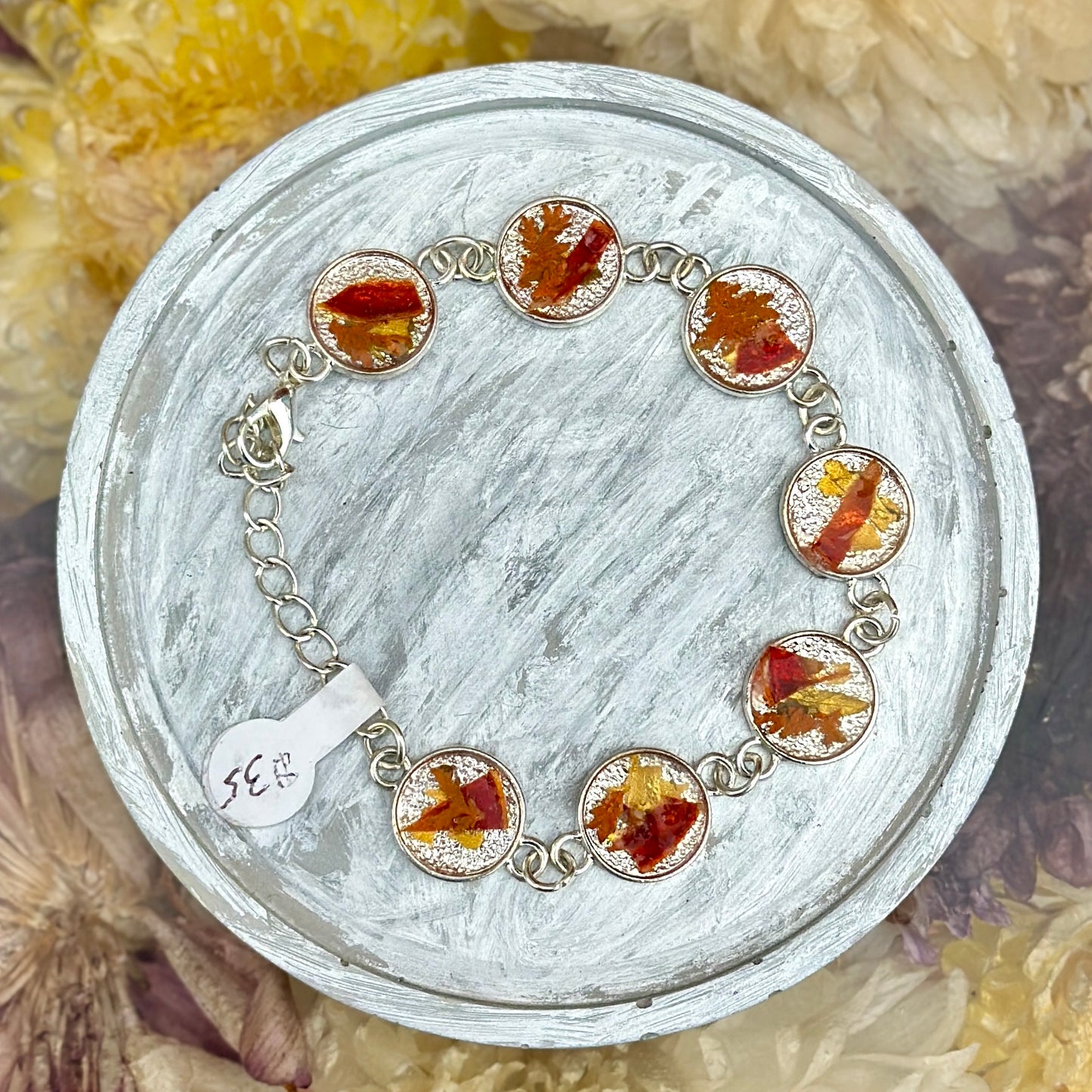 Autumn botanical bracelet with 7 baubles in silver setting (orange, red, and yellow)