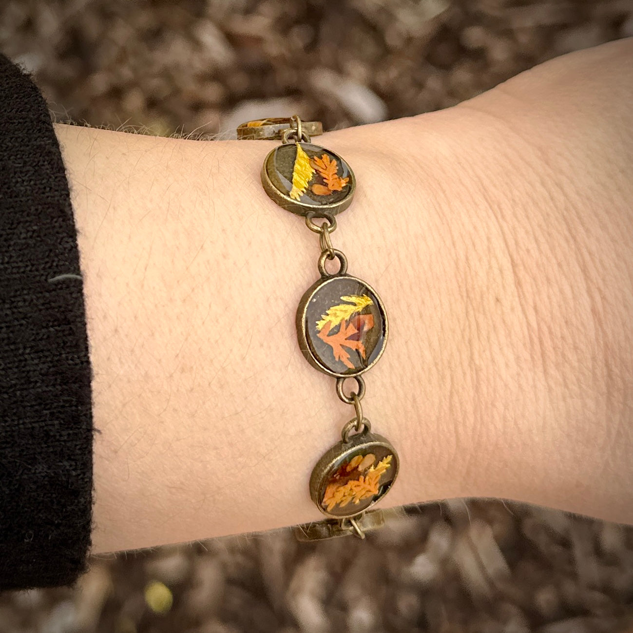 Autumn botanical bracelet with 7 baubles in bronze setting (orange, red, and yellow)