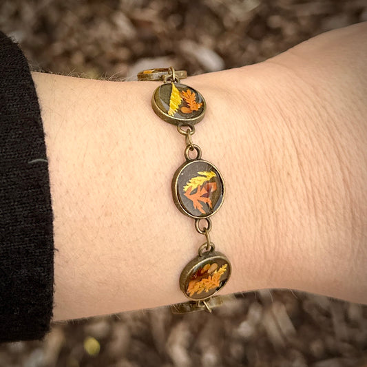 Autumn botanical bracelet with 7 baubles in bronze setting (orange, red, and yellow)