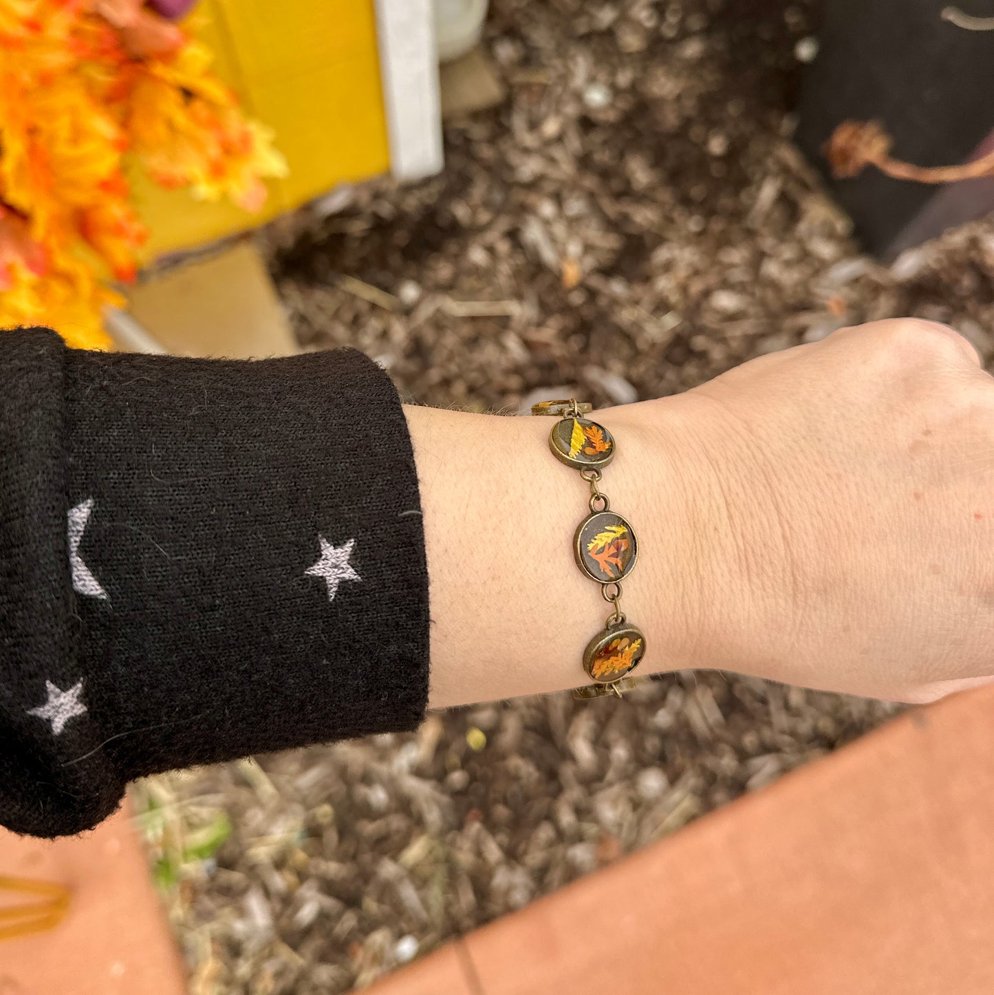 Autumn botanical bracelet with 7 baubles in bronze setting (orange, red, and yellow)