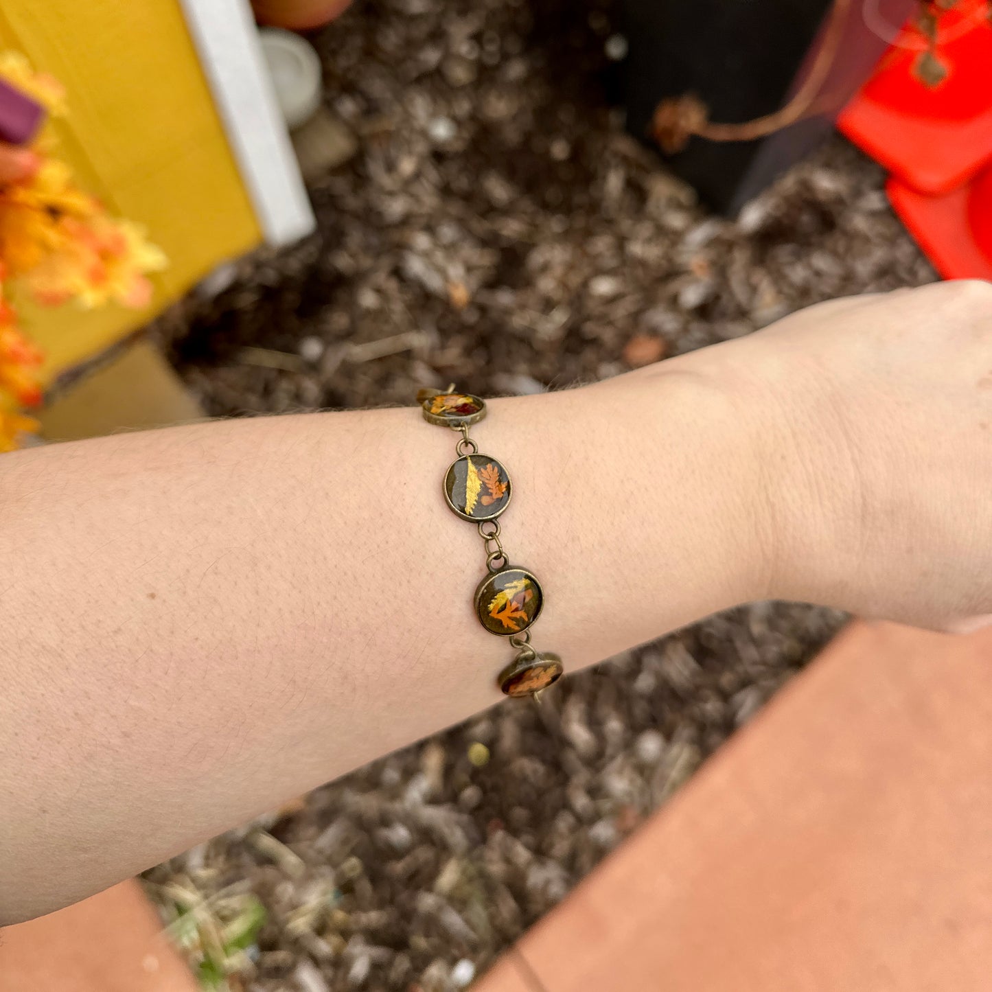Autumn botanical bracelet with 7 baubles in bronze setting (orange, red, and yellow)
