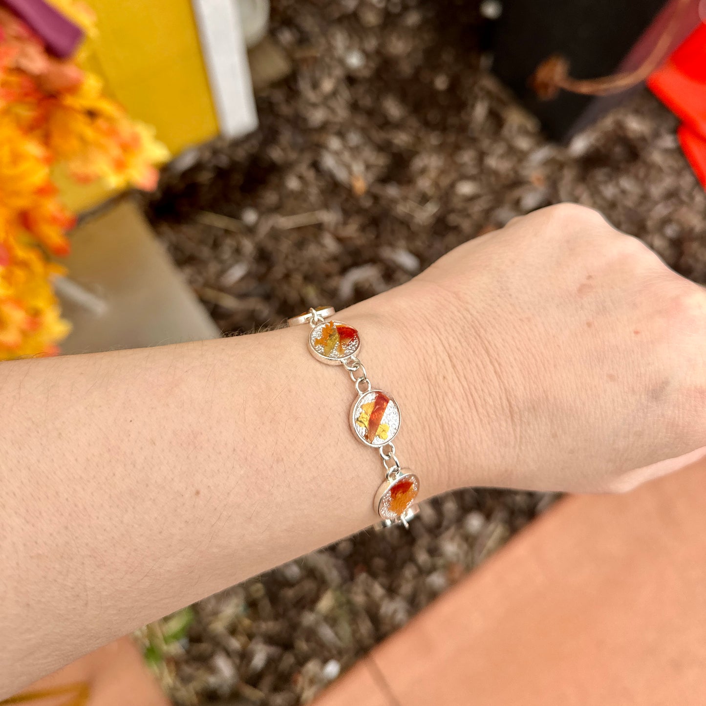 Autumn botanical bracelet with 7 baubles in silver setting (orange, red, and yellow)