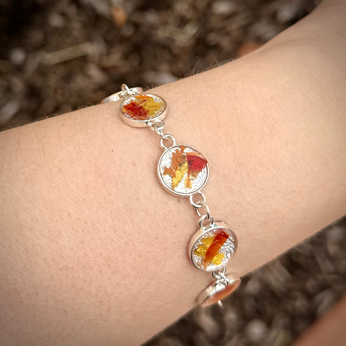 Autumn botanical bracelet with 7 baubles in silver setting (orange, red, and yellow)