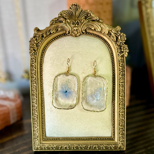Gold-framed botanical earrings in pale indigo