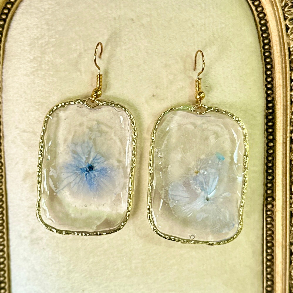 Gold-framed botanical earrings in pale indigo