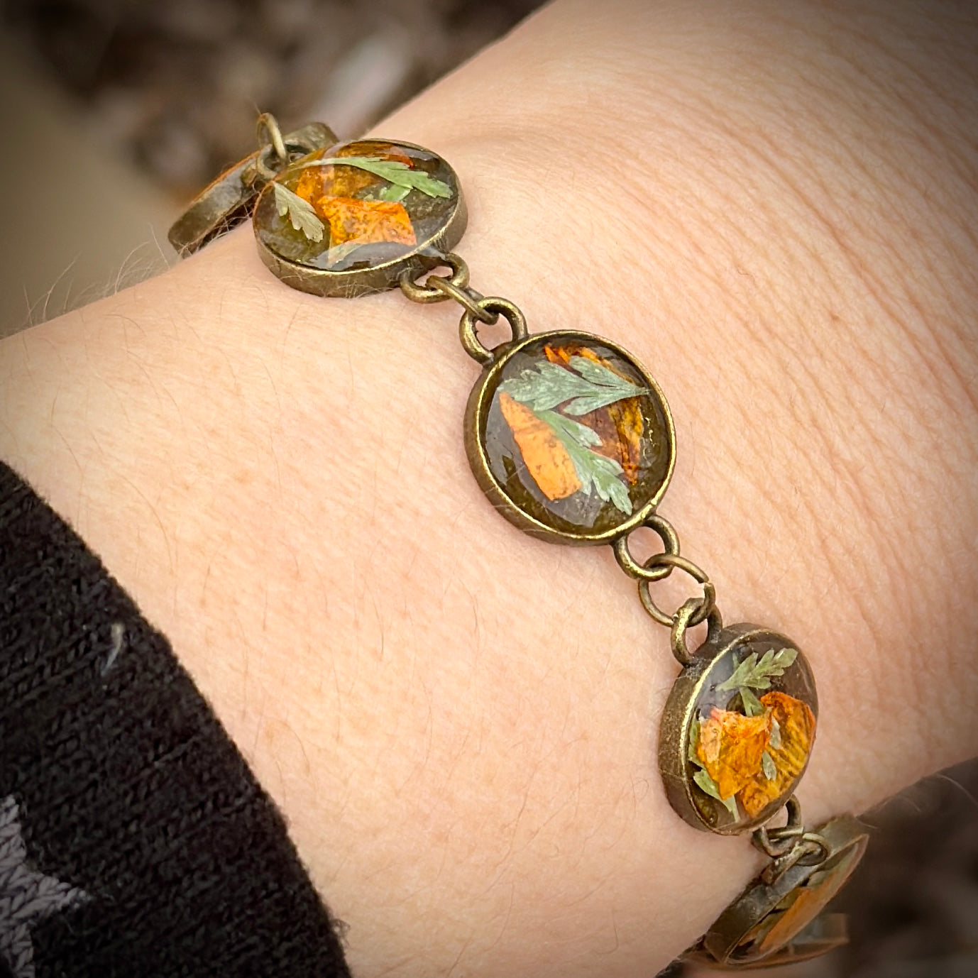 Autumn botanical bracelet with 7 baubles in bronze setting (orange and green)